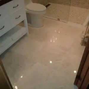 Polished marble tiles in an 18-inch square format with underfloor radiant heating system make for a very comforting bathroom.
