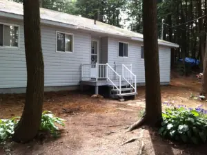 The original cottage was a humble boxy design that connected to a flagstone walkway at the driveway via an unstable deck with flimsy aluminum railing.