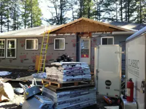 The framing phase of the cottage renovation added a gable roof above the entry door to indicate its location.