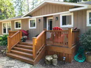 This cedar deck features a formal railing and newel posts, vertical skirting and is maintained with an annual re-application of the deck finish.