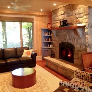 A massive stone fireplace is the centrepiece in this cottage Living Room near Bracebridge, Ontario.