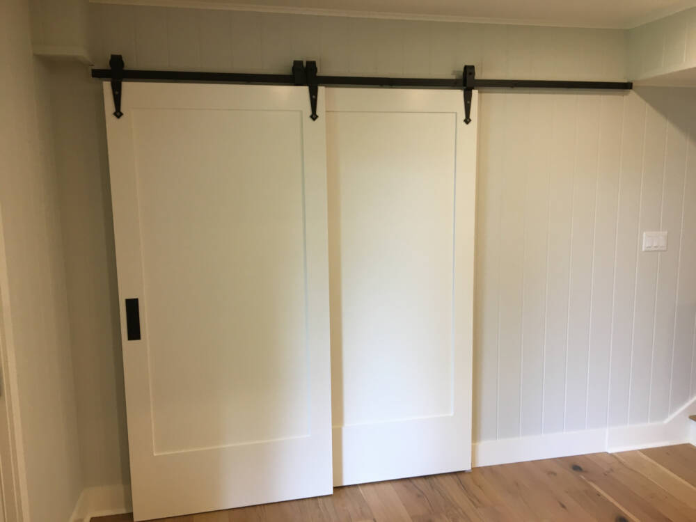 A double, telescoping barn-style sliding door allows the Den space to be made private in this Muskoka builder's construction project.