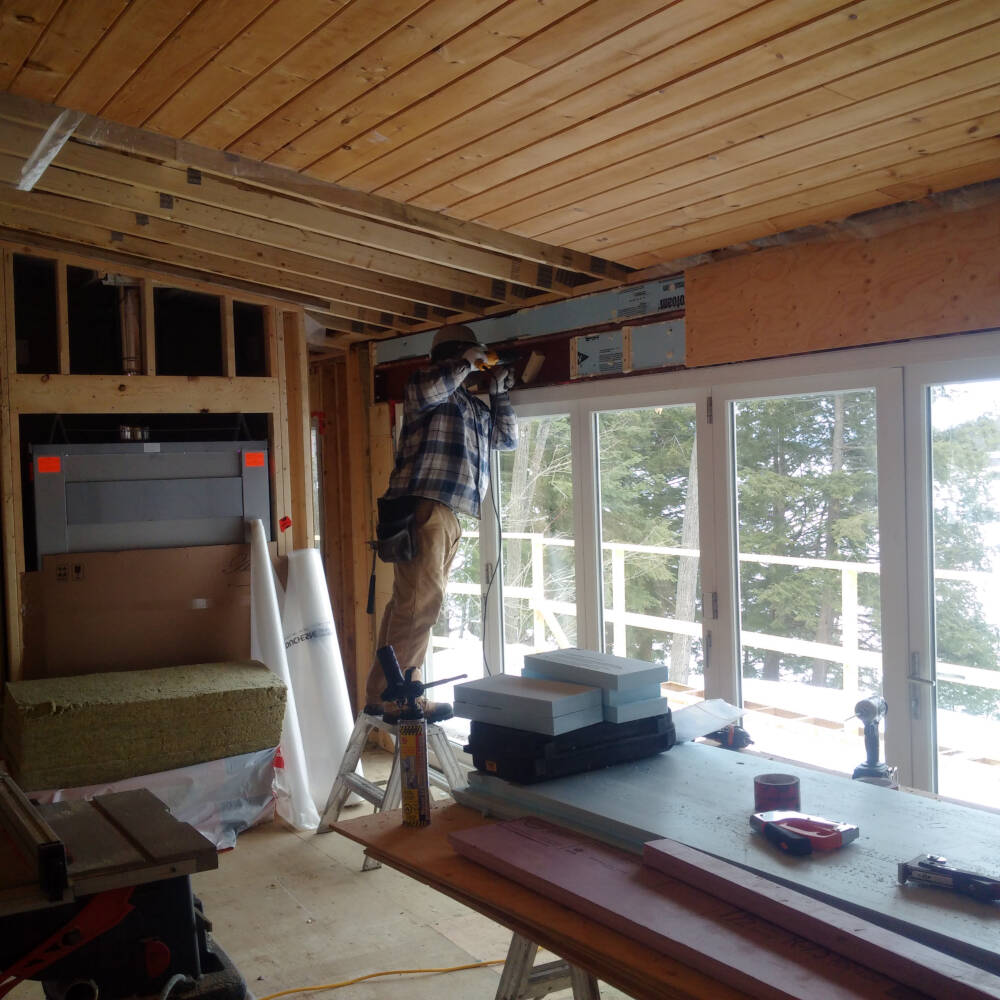 A carpenter installs wood blocking to support finishes to be installed over structural steel construction on Lake Muskoka.