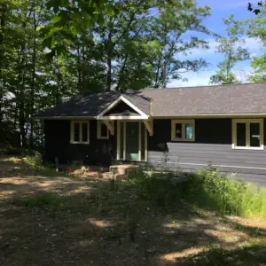 A gable-roof covered entry decorates the entry door to this cottage on Lake Muskoka.
