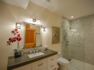 A red orchid sings atop the vanity countertop in a luxury bathroom project near Gravenhurst, Ontario.