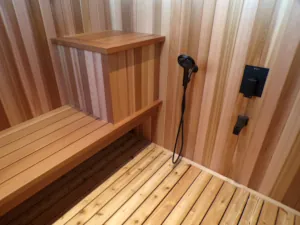 Matte black sauna faucet is contrasted against glowing clear cedar paneling in a Muskoka sauna.