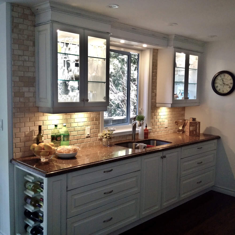 Undercabinet lighting illuminates the textured surface of brick pattern backsplash tiles in this Muskoka cottage kitchen design.