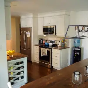 A custom kitchen design by Wes Vibert Custom Woodworking Design features crown mould, glazed cabinet finish and hard-surface countertops.