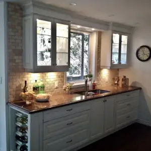 An attractive tile backsplash and kitchen cabinets that transmit daylight from windows at their back are part of this luxury kitchen on MacKay Lake.