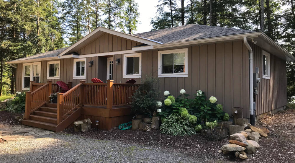 Vertical wood cladding and cedar deck at the entry to this Muskoka custom cottage in the Township of Lake of Bays, Muskoka, Ontario.