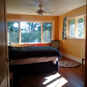 This cottage design's interior is finished in natural pine paneling that provides a naturally warm aesthetic and is durable.