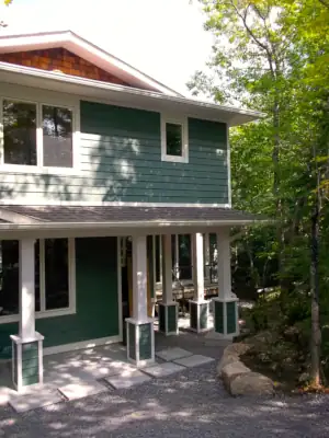 A constrained building footprint requires that this cottage design use offset upper and lower storey footprints to accomodate the required sleeping and living spaces.