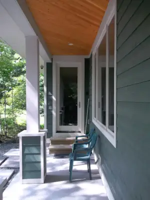 The overhang created by the offset upper and lower storeys provides a sheltered exterior circulation path to access the waterfront from the driveway on this Muskoka cottage property.