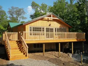 Late afternoon sun shines on the sun deck on the riverside elevation of this house design.