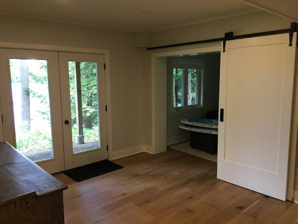 Barn-style sliding doors enclosing the Den in a cottage design on Lake Muskoka.