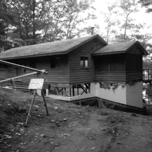A photo taken during construction work shows the existing wood frame building on a new I.C.F. foundation designed by Classic Muskoka Homes.