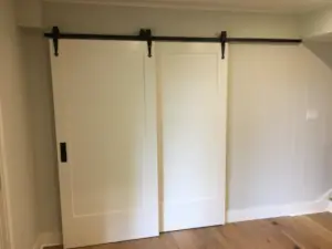 Sliding barn-style doors provide sanctuary in the Den and Television room in the walkout basement of this home design.