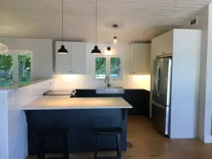 Casual dining area integrates into the quartz countertop from IKEA in this home design's kitchen.