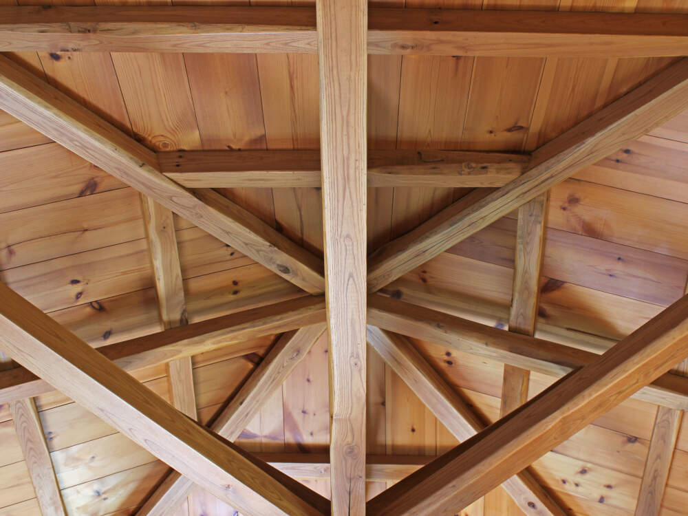 Geometric arrangement of timbers in a timberframe roof structure adds visual interest and depth to timberframe home interiors.